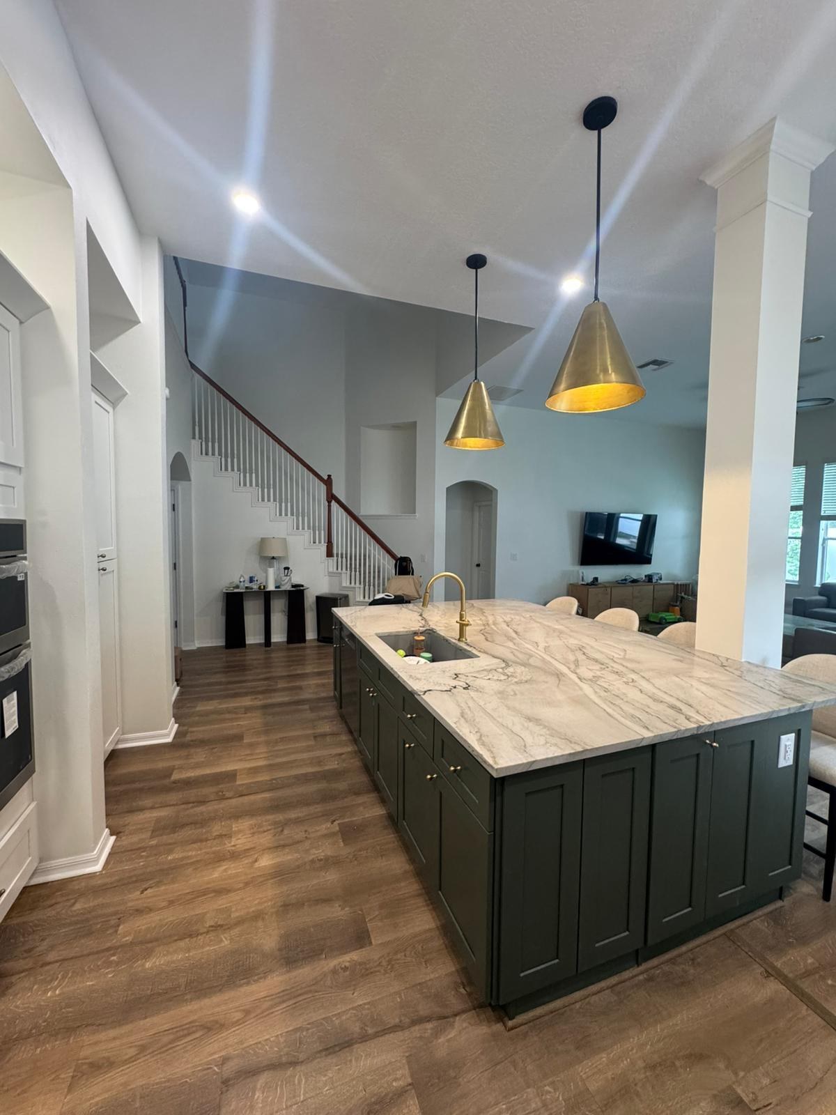 Kitchen remodel with dark island and pendant lights